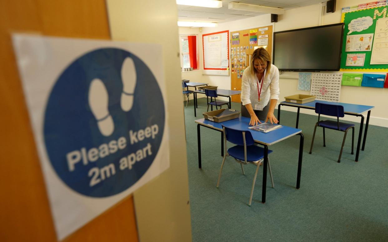 A social distancing sign is seen as teacher Rhiannon Sharman makes preparations for Watlington Primary School to reopen to children on June 1 - Eddie Keogh/Reuters