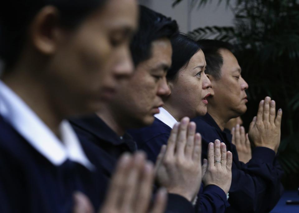 Volunteers from Taiwan pray for the passengers aboard Malaysia Airlines MH370 at Lido Hotel in Beijing