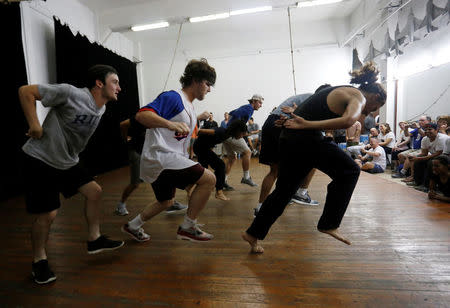 A dancer with Cuba's National Ballet School (R) dances with players from Rice University's baseball team, which had to cancel four of their five exhibition games against Cuban professional teams when Fidel Castro died during their visit here, in Havana, Cuba, December 1, 2016. REUTERS/Stringer