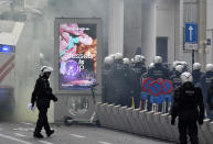Riot police officers deployed to block the street during a protest against coronavirus measures in Brussels, Belgium, Sunday, Dec. 5, 2021. Hundreds of people marched through central Brussels on Sunday to protest tightened COVID-19 restrictions imposed by the Belgian government to counter the latest spike in coronavirus cases. (AP Photo/Geert Vanden Wijngaert)