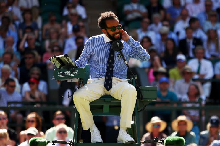 Chair umpire Kader Nouni swats flying ants during the second round match between Johanna Konta of Great Britain and Donna Vekic of Croatia. (Getty Images)