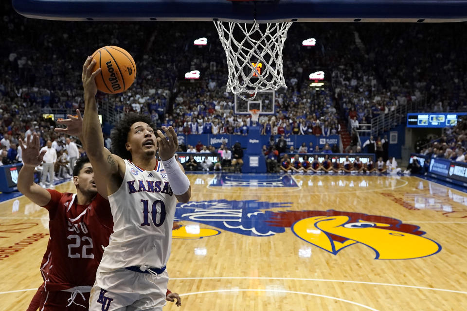 Kansas forward Jalen Wilson (10) gets past Southern Utah center Parsa Fallah (22) to put up a shot during the first half of an NCAA college basketball game Friday, Nov. 18, 2022, in Lawrence, Kan. (AP Photo/Charlie Riedel)