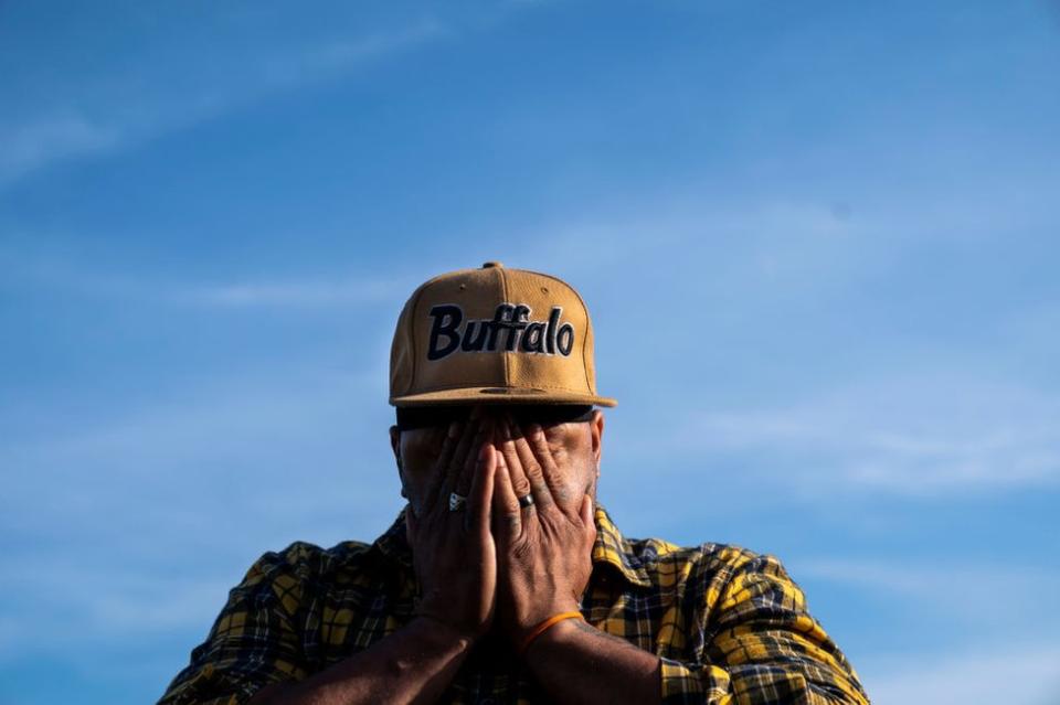 Curtis Hawkins, de Buffalo, se cubre la cara con las manos cerca de un monumento a las víctimas de un tiroteo masivo en Tops Friendly Market en Jefferson Avenue y Riley Street el jueves 19 de mayo de 2022 en Buffalo, NY.