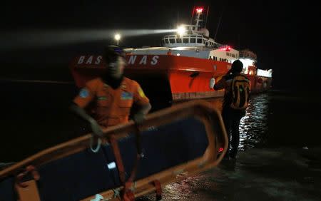 A Search and Rescue team member carries a stretcher as he gets ready to board SAR ship Purworejo for search operations for passengers onboard AirAsia flight QZ8501 at Kumai port, Pangkalan Bun district December 31, 2014. REUTERS/Beawiharta