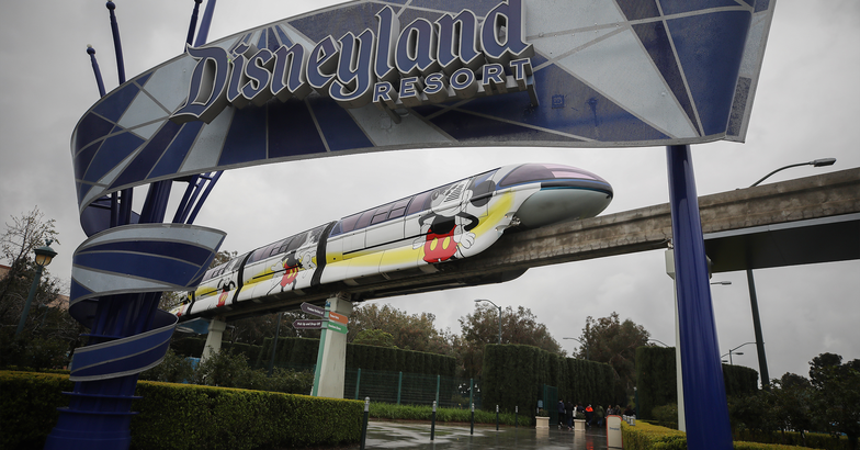 The monorail passes an entrance gate to the famed amusement park Disneyland