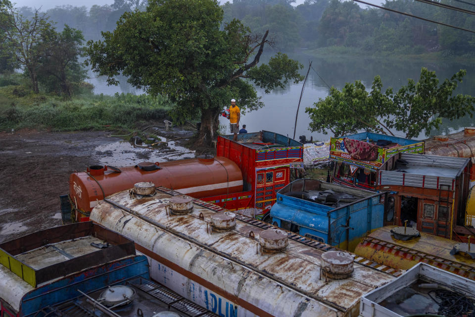 Before being deployed to rural villages to distribute water to wells, tankers park on the Bhatsa River bank in Sapgaon, northeast of Mumbai, India, Saturday, May 6, 2023. The water is pulled from the river and treated with chlorine. One study found that the Bhatsa River is polluted by fish farms and cement factories. Another government report noted the lack of sewage treatment plants, which impacts water quality. (AP Photo/Dar Yasin)