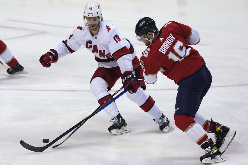 Florida Panthers center Aleksander Barkov (16) and Carolina Hurricanes defenseman Dougie Hamilton (19) go after the puck during the first period at an NHL hockey game Thursday, April 22, 2021, in Sunrise, Fla. (AP Photo/Marta Lavandier)