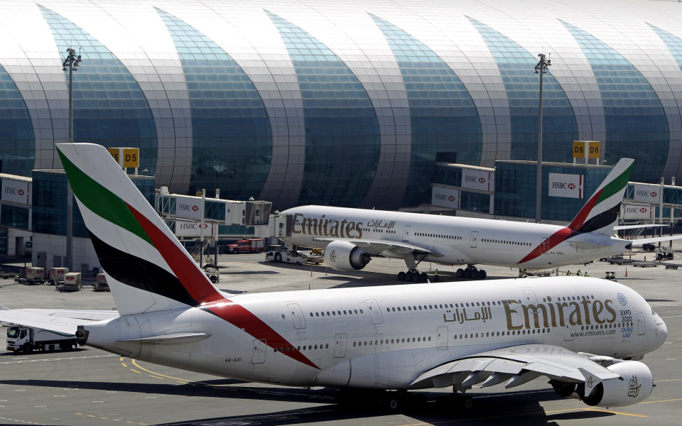 Emirates passenger planes are parked at their gates at Dubai airport in United Arab Emirates, Thursday, May 8, 2014. The parent company of the Middle East's biggest airline, Emirates, posted an annual profit Thursday of $1.1 billion as it enjoyed a dip in fuel costs and boosted capacity with the addition of two dozen new planes. (AP Photo/Kamran Jebreili)