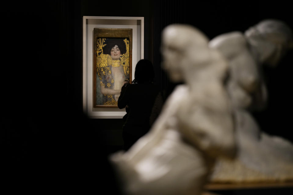 A woman admires Gustav Klimt's oil on canvas painting "Judith I" (1901) on display at the exhibition "Klimt. The Secession and Italy" at the Museum of Rome, in Palazzo Braschi, Rome, during a press preview, Tuesday, Oct. 26, 2021. The exhibition, that explores Klimt's period in Italy, will be open to visitors from Oct.27, 2021 to March 27, 2022. (AP Photo/Andrew Medichini)