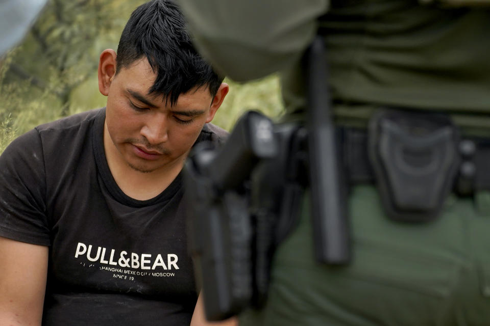 A migrant answers questions after being apprehended by U.S. Border Patrol agents in the desert at the base of the Baboquivari Mountains, Thursday, Sept. 8, 2022, near Sasabe, Ariz. The desert region located in the Tucson sector just north of Mexico is one of the deadliest stretches along the international border with rugged desert mountains, uneven topography, washes and triple-digit temperatures in the summer months. Border Patrol agents performed 3,000 rescues in the sector in the past 12 months. (AP Photo/Matt York)