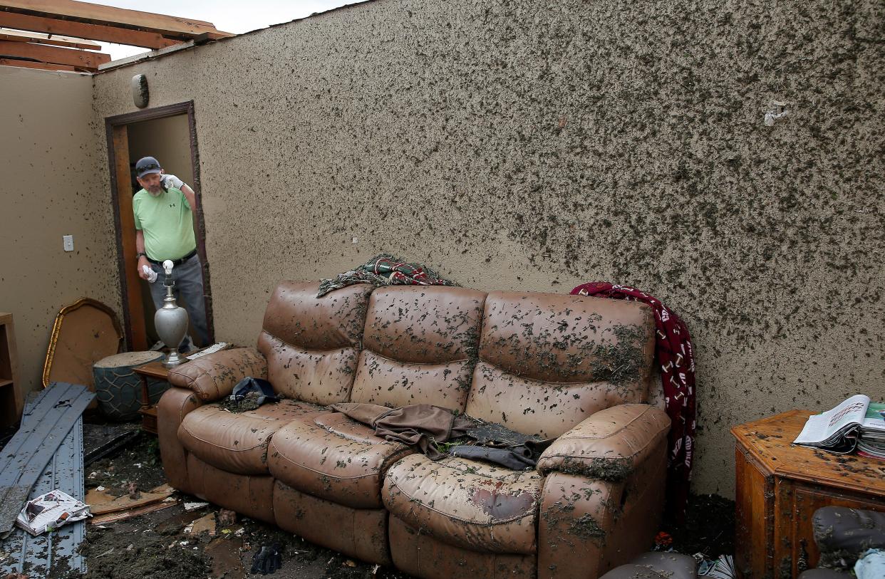 Jeff Totten looks at damage in his living room of his home,  Thursday, April, 20, 2023, in Shawnee, Okla., after tornado moved through the area Wednesday night in Shawnee, Okla.