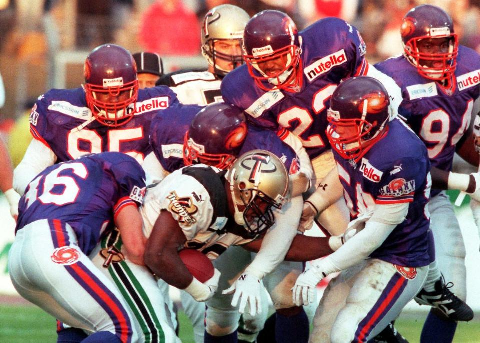 George Harris of the Berlin Thunder is tackled by Jim Cantelupe (36), Vince Amey (95), Michael Reed (23), Whit Marshall (front right) and Kendrick Gholston (94) during an NFL Europe match against the Frankfurt Galaxy at Frankfurt's Waldstadium in 1999.