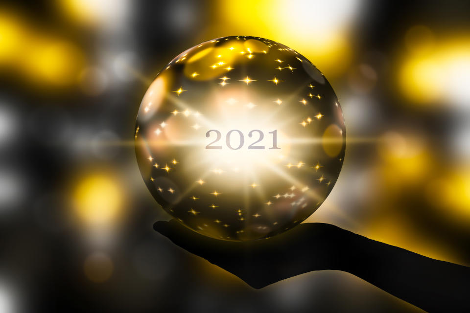 crystal ball in a hand, prediction for new year 2021 on abstract shiny blurred background