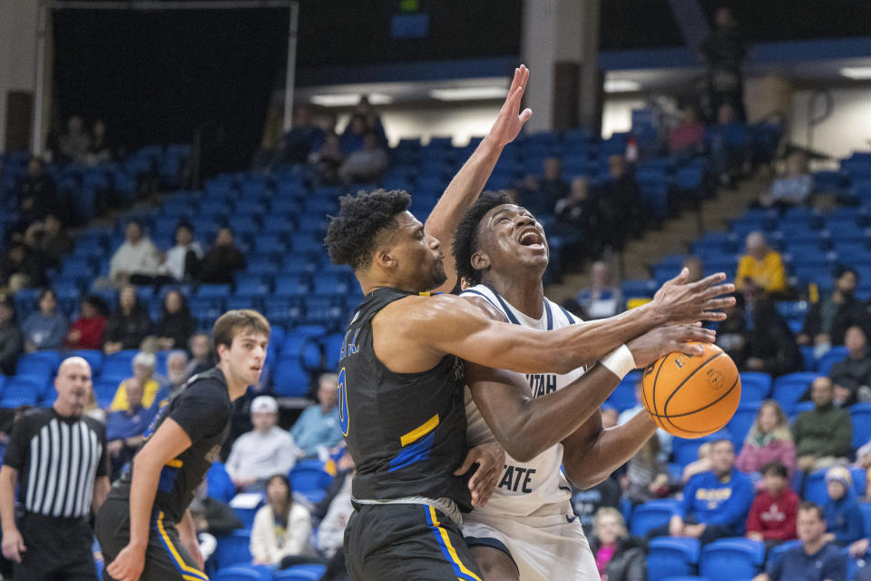 San Jose State guard Myron Amey Jr. (0) tries to block a shot by Utah State forward Great Osobor (1) during the first half of an NCAA basketball game Wednesday, March 6, 2024, in San Jose, Calif. (AP Photo/Nic Coury)