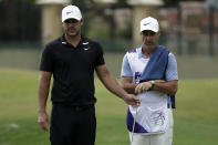 Brooks Koepka looks over a putt with his caddie, Ricky Elliott on the 16th hole during the second round of the World Golf Championship-FedEx St. Jude Invitational Friday, July 31, 2020, in Memphis, Tenn. (AP Photo/Mark Humphrey)