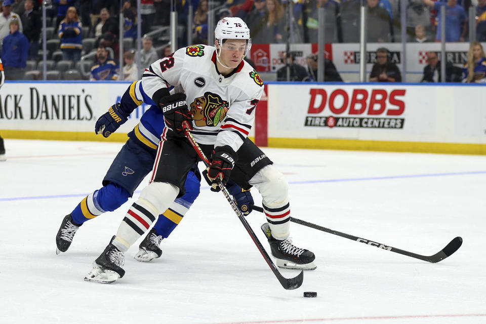 Chicago Blackhawks' Alex Vlasic (72) controls the puck in front of St. Louis Blues' Torey Krug (47) during the third period of an NHL hockey game Wednesday, April 10, 2024, in St. Louis. (AP Photo/Scott Kane)