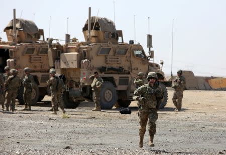 A U.S. soldier runs at a coalition forces forward base near West Mosul, Iraq June 21, 2017, where Iraqi security forces are fighting Islamic State. REUTERS/Marius Bosch