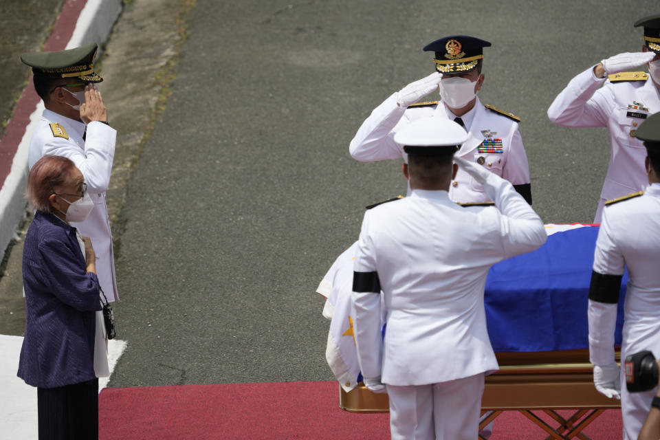 Widow and former first lady Amelita Ramos, left, with military chief Lieutenant General Bartolome Vicente Bacarro, second from left, stands beside the flag-draped casket of her husband, the late former Philippine President Fidel V. Ramos, during his state funeral at the Heroes' Cemetery in Taguig, Philippines on Tuesday Aug. 9, 2022. Ramos was laid to rest in a state funeral Tuesday, hailed as an ex-general, who backed then helped oust a dictatorship and became a defender of democracy and can-do reformist in his poverty-wracked Asian country. Ramos died at age 94. (AP Photo/Aaron Favila)