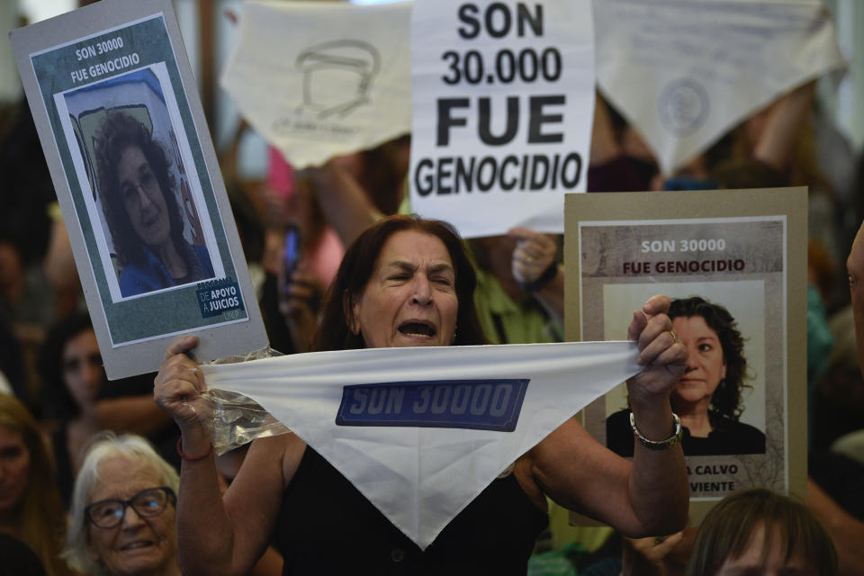 La familiar de una víctima de expolicías y exmilitares, acusados de crímenes de lesa humanidad durante la dictadura, protesta ante el tribunal antes de la lectura del veredicto en su juicio en La Plata, Argentina, el martes 26 de marzo de 2024. (AP Foto/Gustavo Garello)