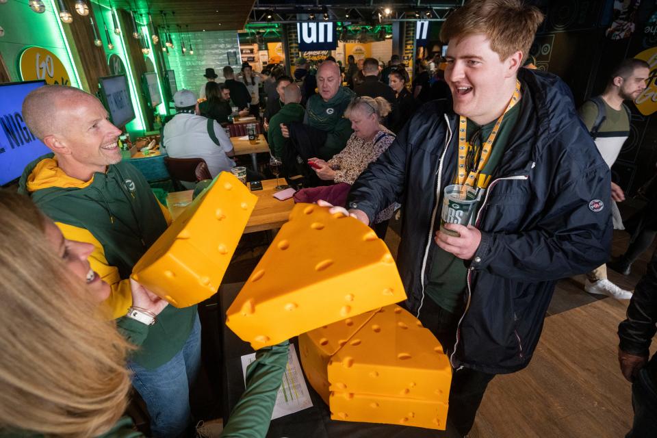 Englishman Alex Hardman purchases a pair of cheeseheads for about $65 each during the last of three pep rallies put on by the Green Bay Packers on Saturday in London.