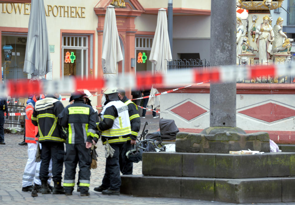 Firefighters stay together at the scene of an incident in Trier, Germany, Tuesday, Dec. 1, 2020. German police say people have been killed and several others injured in the southwestern German city of Trier when a car drove into a pedestrian zone. Trier police tweeted that the driver had been arrested and the vehicle impounded. (Harald Tittel/dpa via AP)