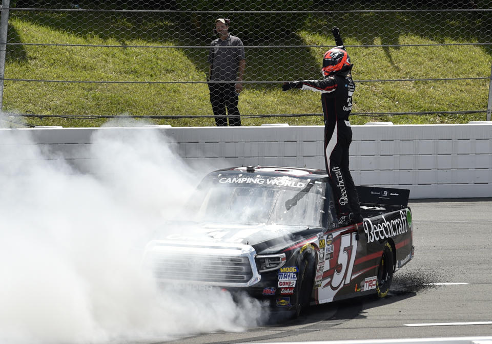 FILE - In this July 28, 2018, file photo, Kyle Busch celebrates after winning a NASCAR Truck Series auto race in Long Pond, Pa. Busch says, “Bring it on.” Chase Elliott and Kyle Larson are the latest topflight drivers to accept the challenge of Kevin Harvick, who has offered half of a $100,000 bounty to any Cup Series driver who can beat the versatile Busch in a Truck Series race this year. (AP Photo/Derik Hamilton, File)