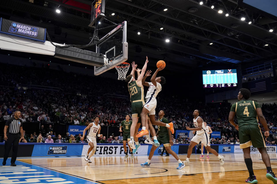 Virginia guard Reece Beekman, center right, shoots against Colorado State's Joe Palmer (20) during the first half of a First Four college basketball game in the NCAA Tournament in Dayton, Ohio, Tuesday, March 19, 2024. (AP Photo/Jeff Dean)