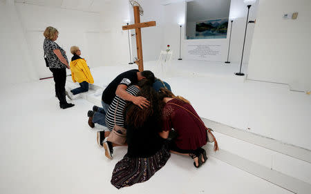 People pray in the First Baptist Church of Sutherland Springs where 26 people were killed in a shooting attack last week, as the church was opened to the public as a memorial to those killed, in Sutherland Springs, Texas, U.S. November 12, 2017. REUTERS/Rick Wilking