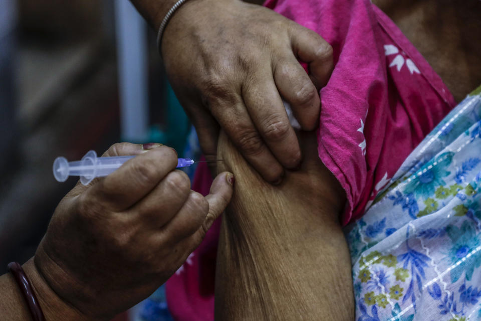 A health worker administers a dose of Covaxin COVID-19 vaccine at a health center in Garia , South 24 Pargana district, India, Thursday, Oct. 21, 2021. India has administered 1 billion doses of COVID-19 vaccine, passing a milestone for the South Asian country where the delta variant fueled its first crushing surge this year. (AP Photo/Bikas Das)