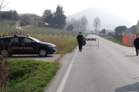 Police officers control the road to Vo' Euganeo, a town of 3,500 people at the epicenter of the Veneto cluster, Monday, Feb. 24, 2020. Police manned checkpoints around quarantined towns in Italy's north on Monday and residents stocked up on food as the country became the focal point of the virus outbreak in Europe and fears of its cross-border spread. (AP Photo/Andrea Casalis)