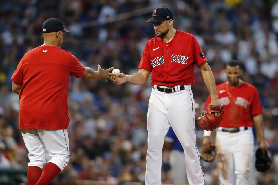Boston Red Sox's Nathan Eovaldi, center, hands the ball to manager Alex Cora as he is removed during the third inning of the team's baseball game against the Toronto Blue Jays, Friday, July 22, 2022, in Boston. (AP Photo/Michael Dwyer)