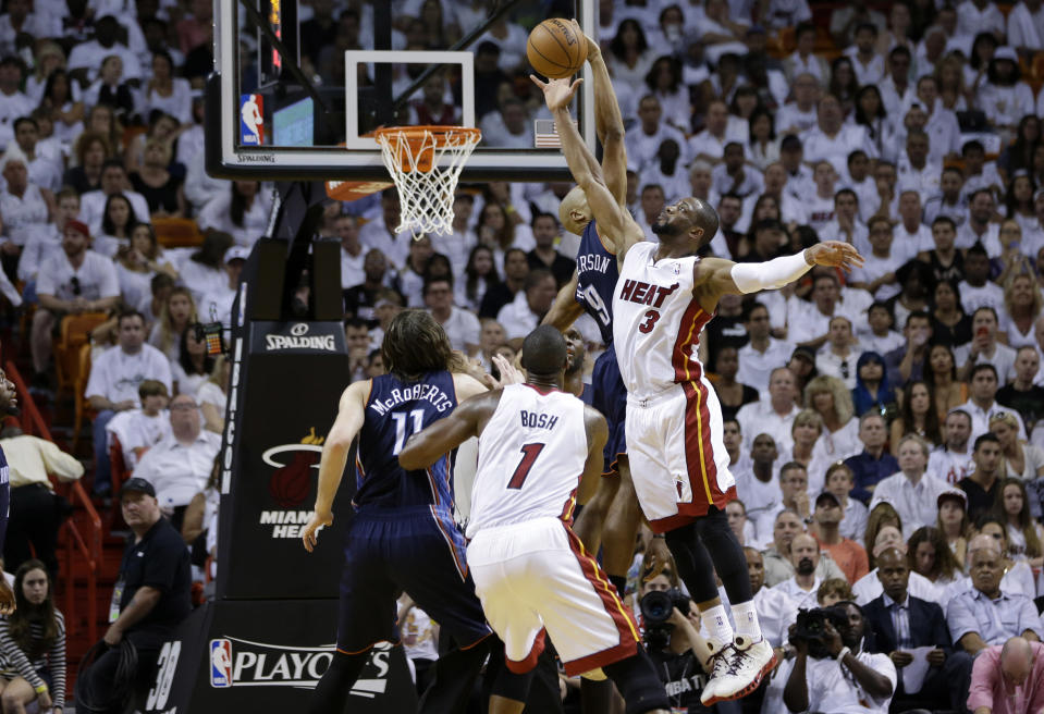 Dwyane Wade (3), del Heat de Miami, intenta un tiro de campo en contra de Gerald Henderson, segundo de derecha a izquierda, en la segunda mitad del primer juego de la serie de la ronda de apertura de los playoffs de la NBA el domingo 20 de abril de 2014, en Miami. El Heat venció a los Bobcats 99-88. (Foto AP/Lynne Sladky)