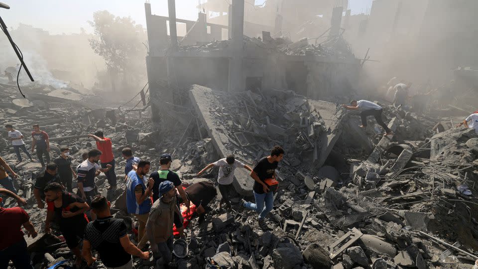 People search for survivors and the bodies of victims in the rubble of buildings destroyed during an Israeli bombardment in southern Gaza on October 26, 2023, amid the ongoing battles between Israel and the Palestinian group Hamas. - Mahmud Hams/AFP/Getty Images