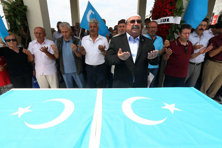 Turkish Muslim Uighurs pray for members of their community allegedly killed by the Chinese security forces in China's far-western Xinjiang autonomous region, in Ankara, on July 4, 2014