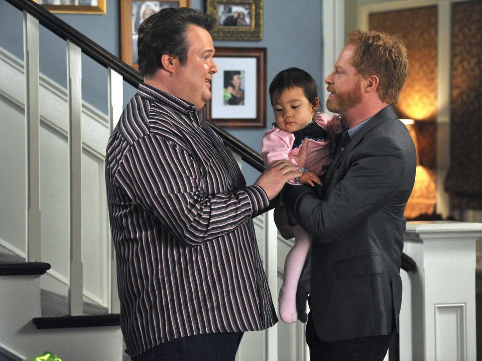 Modern Family's Mitch and Cam holding Lily