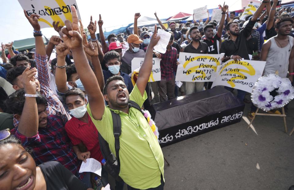 People protest with a coffin with a slogan in Sinhalese that reads " the death of state sovereignty" during an ongoing protest outside president's office in Colombo, Sri Lanka, Saturday, April 23, 2022. Thousands of Sri Lankans have protested outside President Gotabaya Rajapaksa’s office in recent weeks, demanding that he and his brother, Mahinda, who is prime minister, quit for leading the island into its worst economic crisis since independence from Britain in 1948. (AP Photo/Eranga Jayawardena)