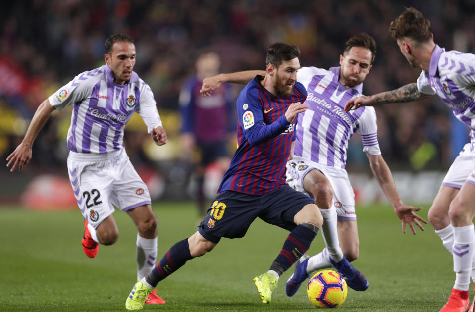 Barcelona forward Lionel Messi, center, is challenged by Valladolid's Nacho Martinez, left, and Michel Herrero during the Spanish La Liga soccer match between FC Barcelona and Valladolid at the Camp Nou stadium in Barcelona, Spain, Saturday, Feb. 16, 2019. (AP Photo/Manu Fernandez)