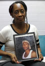 Veronica Parker holds a photo of her son, Korey B. Parker, Sr., 27, at her workplace in Chicago, Friday, Nov. 9, 2018. He was fatally shot around the corner from her house on July 4, 2012. The killing remains unsolved. Parker is a member of Purpose Over Pain, a support group for parents who've lost children to gun violence but, she says, "there’s a void in my life that will never be filled." (AP Photo/Nam Y. Huh)