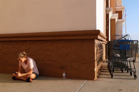 Amanda Jones, 34, of Lynn Haven, takes advantage of free wireless internet at a Wal-Mart to check her phone, following cellular network disruptions in the aftermath of Hurricane Michael in Lynn Haven, Florida, U.S., October 14, 2018. REUTERS/Terray Sylvester