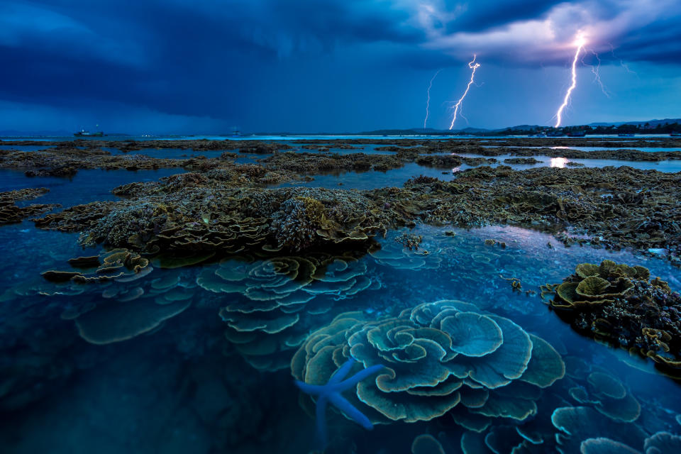 'In the thunderstorm' by @dean_nguyen shows lightning over the coral reefs of  Hon Yen island Vietnam.