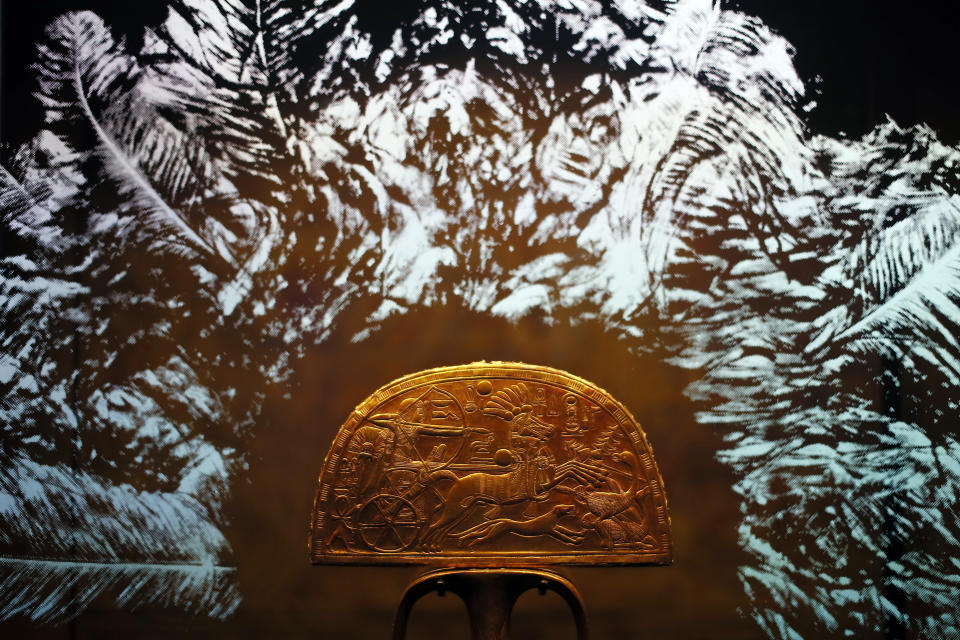 A gilded wooden "Ostrich Hunt" fan is displayed as part of 'Tutankhamun, the treasure of the Pharaoh', an exhibition in partnership with the Grand Egyptian Museum at the Grande Halle of La Villette in Paris, France, Thursday, March 21, 2019. This exhibition, which runs from 23 March to 15 September 2019, will reveal 150 fascinating original objects found in 1922 in the tomb of the most famous Pharaoh. (AP Photo/Francois Mori)