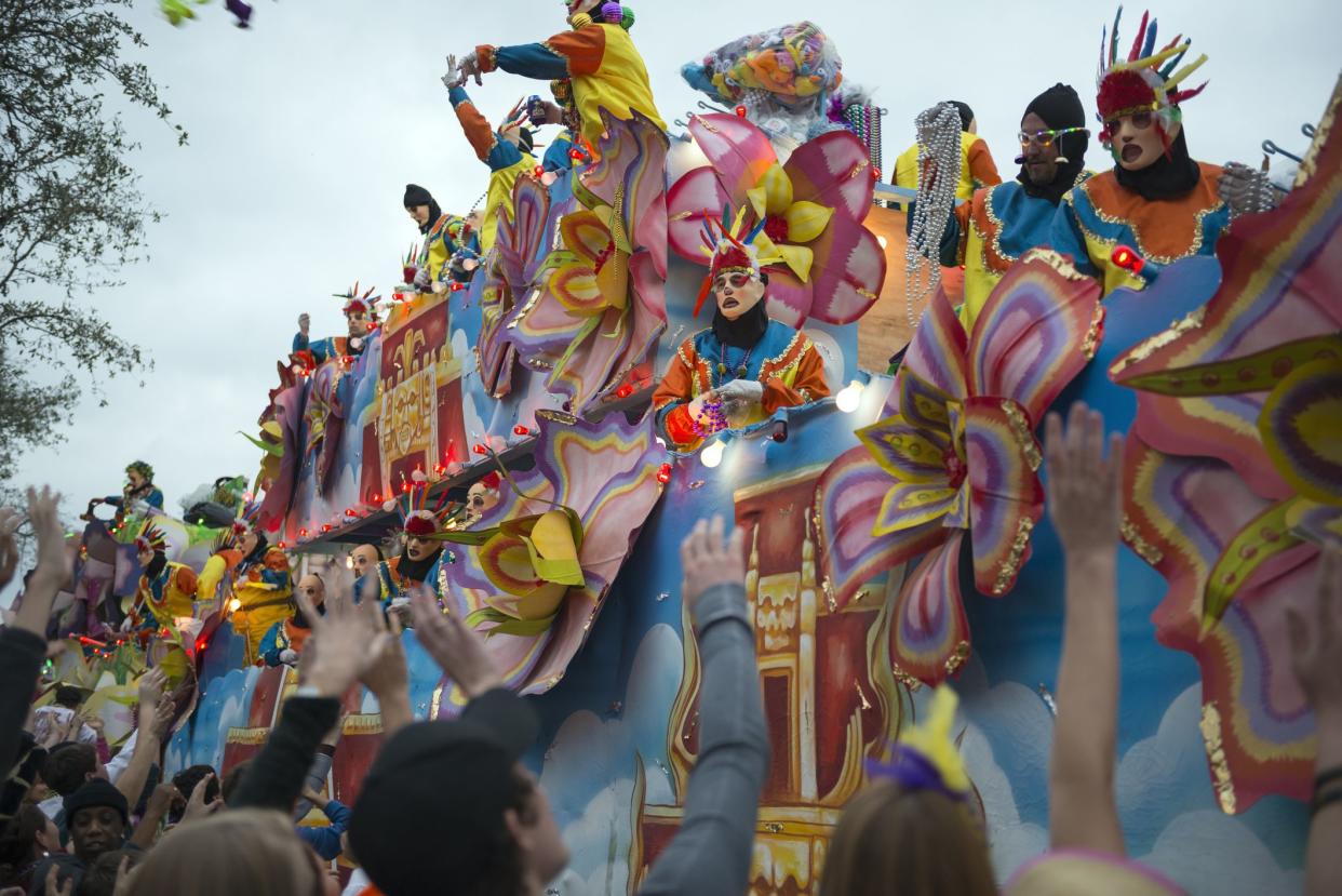 New Orleans, USA - February 9, 2013: Costumed men on a float throw beads into the crowd during a Mardi Gras parade (Krewe of Endymion) on Canal Street in New Orleans, Louisiana