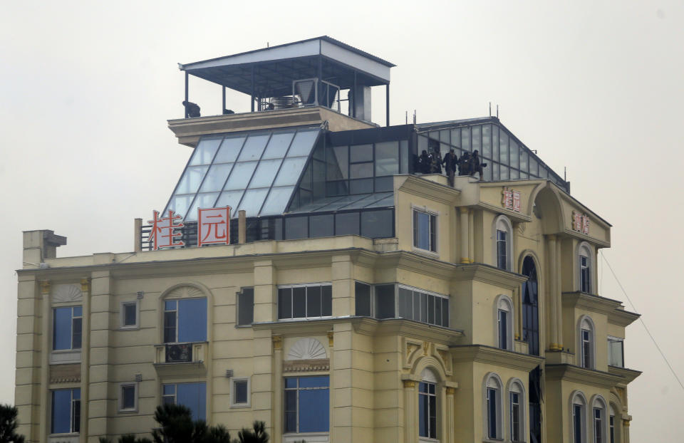 Taliban fighters are seen in the rooftop of a hotel building during a gunfire in the city of Kabul, Afghanistan, Monday, Dec. 12, 2022. A Taliban official says that a hotel building has come under a complex attack in the Afghan capital Kabul. (AP Photo)