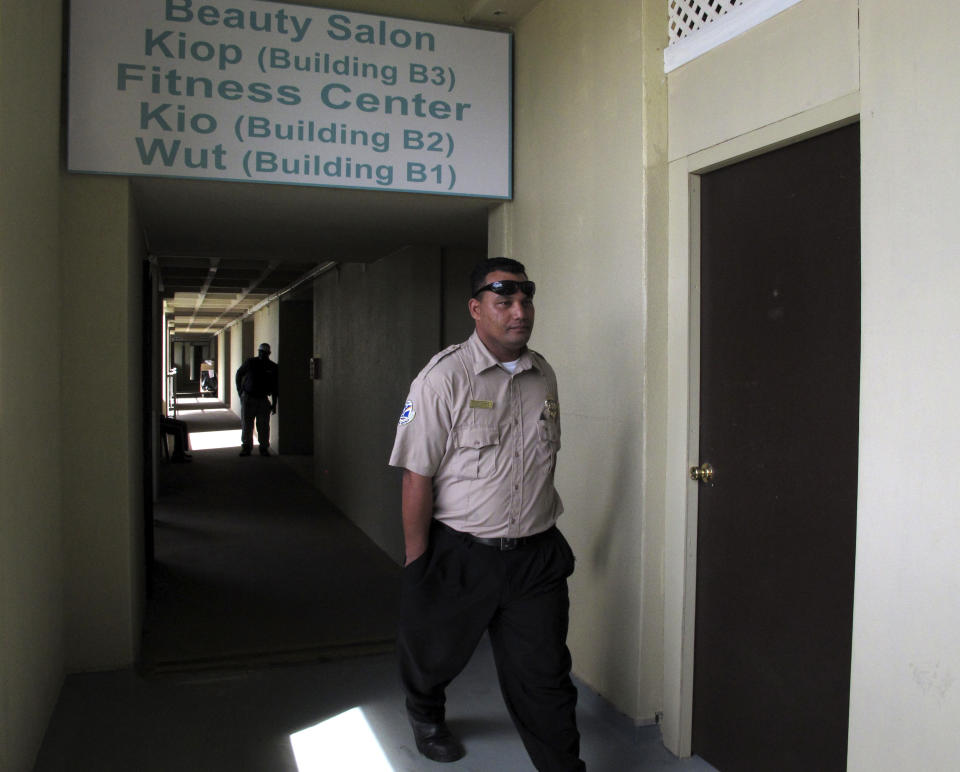 Security personnel guard in front of Jose Salvador Alvarenga's hotel room, seen between the securities, at the Marshall Islands Resort, in Majuro, Sunday, Feb. 9, 2014. The Salvadoran man who says he spent more than a year drifting across the Pacific Ocean before making landfall in the Marshall Islands is too weak to travel and will remain in the island nation for a while, an official said Saturday. (AP Photo/Miki Toda)