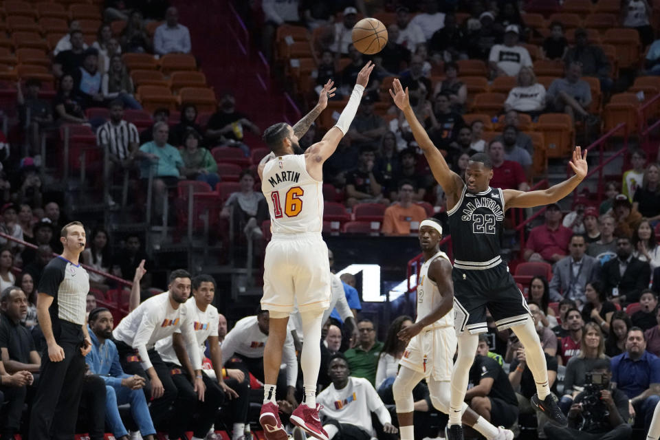 Miami Heat forward Caleb Martin attempts a three-point basket as San Antonio Spurs guard Malaki Branham (22) defends during the first half of an NBA basketball game, Saturday, Dec. 10, 2022, in Miami. (AP Photo/Lynne Sladky)