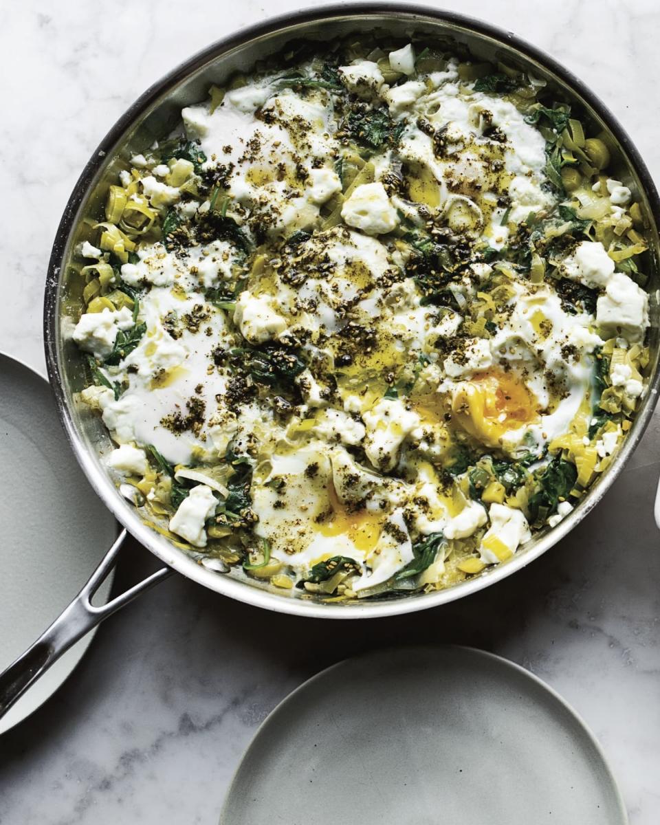 A skillet of leeks and braised eggs with za'atar seasoning