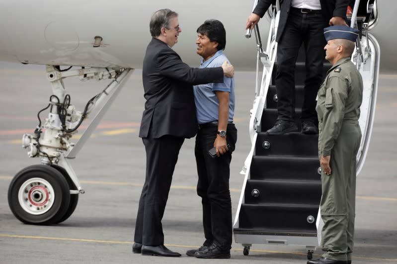 Bolivia's ousted President Evo Morales is welcomed by Mexico's Foreign Minister Marcelo Ebrard during his arrival to take asylum in Mexico, in Mexico City