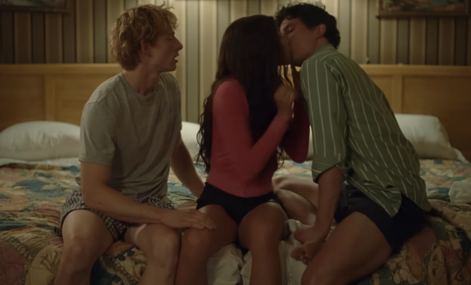 Three actors in a scene from "Challengers," sitting closely on a bed