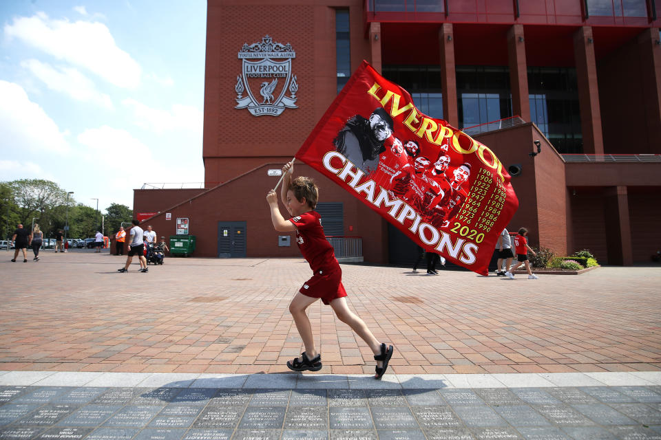 Liverpool fan Dillon Parry waves a flag outside Anfield in Liverpool. (Photo by Martin Rickett/PA Images via Getty Images)