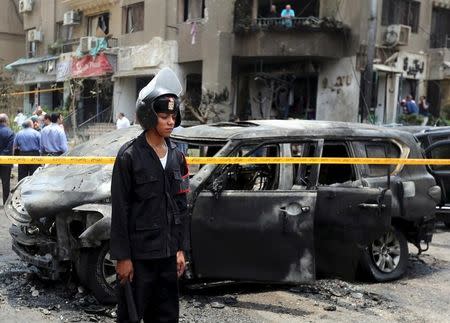 Policemen investigate the site of a car bomb attack on the convoy of Egyptian public prosecutor Hisham Barakat near his house at Heliopolis district in Cairo, Egypt, June 29, 2015. REUTERS/Mohamed Abd El Ghany